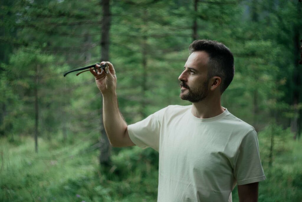 Man examining sustainable eco eyewear sunglasses in the forest